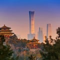 This photo shows the view from Jingshan Park in Beijing, looking past traditional imperial pavilions toward the modern skyscrapers of the Central Business District.