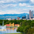 The image shows the Denver skyline and the Rocky Mountains viewed from City Park in Denver, Colorado.