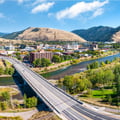 This image shows Missoula, Montana, featuring the Beartracks Bridge crossing the Clark Fork River.