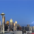 The image shows the Seattle skyline featuring the Space Needle with Mount Rainier in the background.