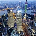 The image shows an aerial view of the Lujiazui Financial District in Pudong, Shanghai, China, featuring iconic skyscrapers like the Shanghai World Financial Center, Jin Mao Tower, and the Oriental Pearl TV Tower.