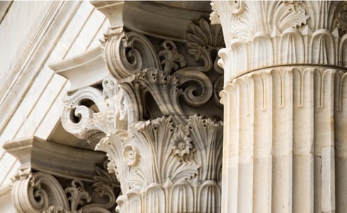 The image appears to show Corinthian columns featuring ornate, carved capitals in a classical or neoclassical architectural style.
