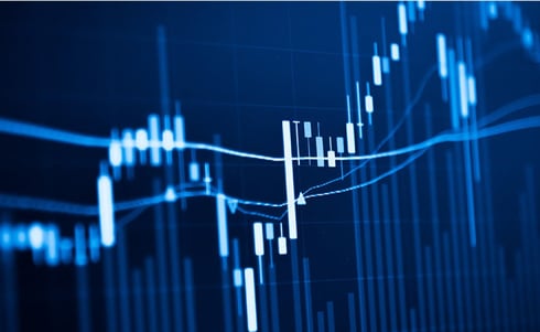 The image shows a blue financial chart with candlestick patterns and moving average lines representing stock market data.
