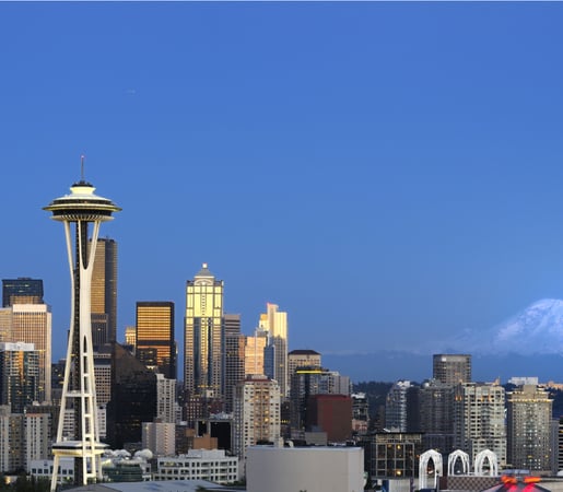 The image shows the Seattle skyline featuring the Space Needle with Mount Rainier in the background.