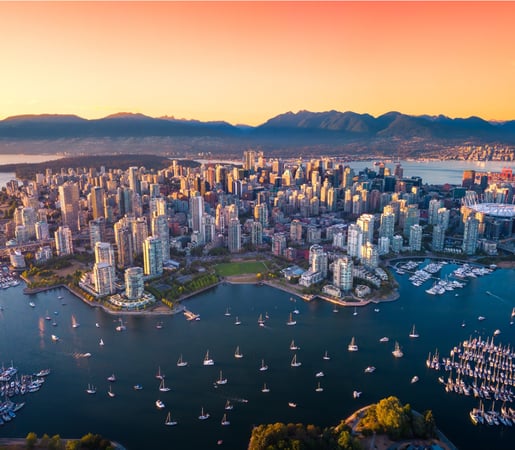 The image appears to show an aerial view of Vancouver, British Columbia, Canada, looking south over False Creek toward the downtown peninsula and the North Shore Mountains.
